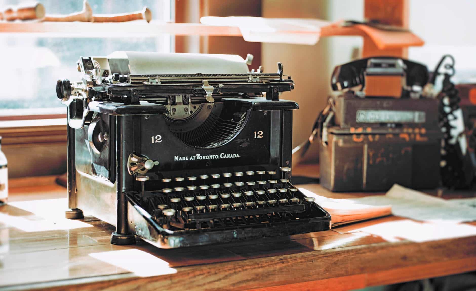 classic black typewriter on brown wooden desk